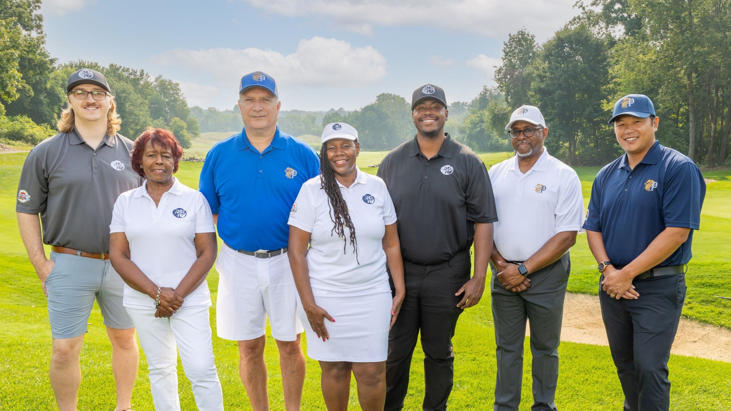 Group of people posing on a golf course